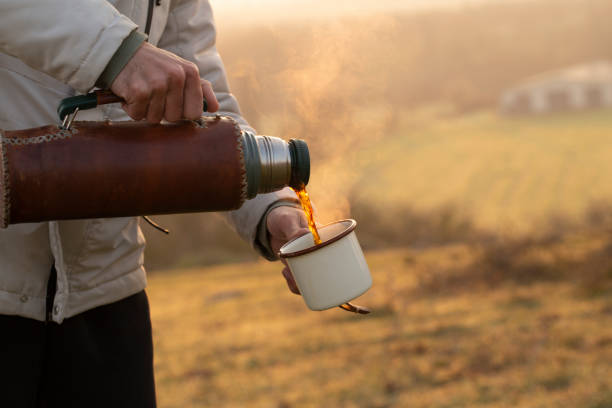 pouring mug of coffee from a hot thermos stock photo