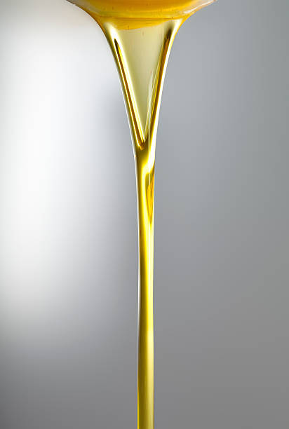 Pouring oil or golden liquid stock photo