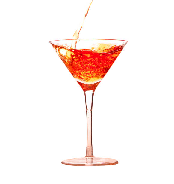 Pouring orange liquid drink into cocktail martini glass stock photo