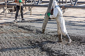 istock Pouring out concrete with ready-mix concrete (RMC) in the construction site. Ready mix concrete is a batch of concrete that is mixed before being delivered. 1353253719