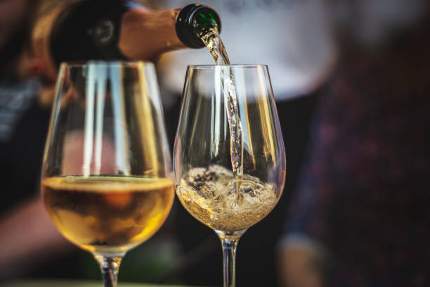 rose champagne gieten in een glas - wijn stockfoto's en -beelden