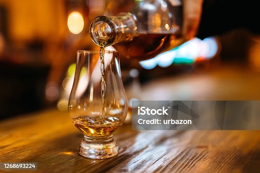 istock Pouring whiskey in glass 1268693224