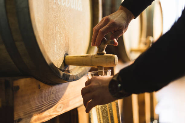 Pouring wine from wine barrel stock photo