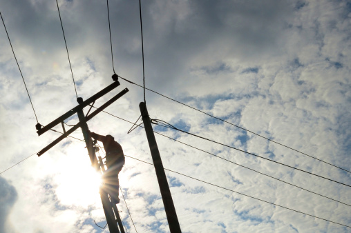 ✓ Electrician worker climbing electric power pole to repair the damaged  power cable line problems after the storm. Power line support,Technology  maintenance and development industry concept Stock Photos