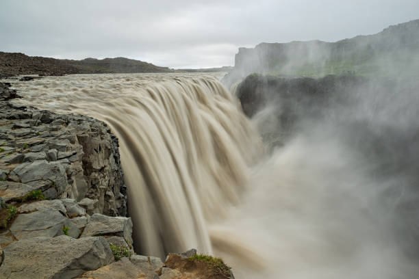 Powerful Dettifoss waterfall in Iceland Powerful Dettifoss waterfall with rising mist and spray, Iceland iceland dettifoss stock pictures, royalty-free photos & images