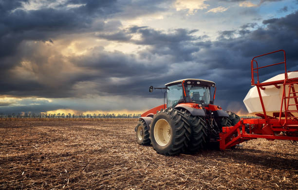 A powerful tractor works in the field Tractor working on the farm, a modern agricultural transport, a farmer working in the field, fertile land, tractor on a sunset background, cultivation of land, agricultural machine agricultural machinery stock pictures, royalty-free photos & images