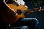 istock Practicing acoustic guitar. Man playing guitar. Guitarist on stage 1316426552
