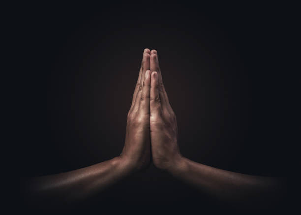 Praying hands with faith in religion and belief in God on dark background. Power of hope or love and devotion. Namaste or Namaskar hands gesture. Prayer position. Praying hands with faith in religion and belief in God on dark background. Power of hope or love and devotion. Namaste or Namaskar hands gesture. Prayer position. namaste greeting stock pictures, royalty-free photos & images