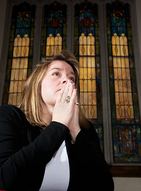 prier femme à genoux dans church, gros plan - good friday photos et images de collection