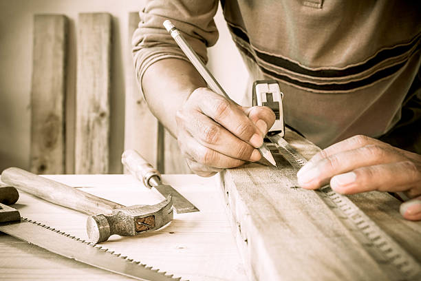 Precision throughout. Serious young male carpenter working with wood. stock photo