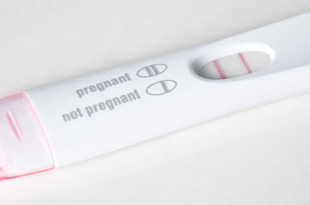 Pregnancy Test Close-Up - Pregnant A pregnancy test closeup on a white bathroon countertop with the results positive and pregnant. positive pregnancy test stock pictures, royalty-free photos & images