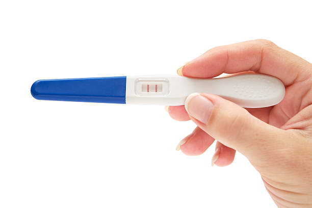 Pregnancy Test Woman holding a positive pregnancy test. Isolated on a white background. positive pregnancy test stock pictures, royalty-free photos & images