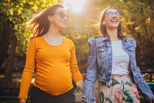 zwanger lesbisch paar in park - pregnant couple outside stockfoto's en -beelden