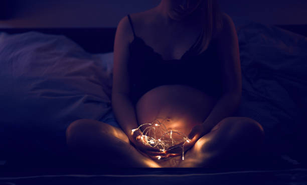 pregnant tummy in the night stock photo