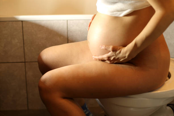 Pregnant woman at toilet stock photo