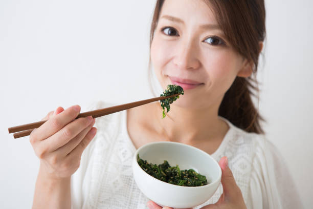 Pregnant woman eats spinach Pregnant woman eats spinach shy japanese woman stock pictures, royalty-free photos & images