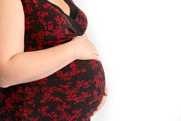 Pregnant woman embracing her belly stock photo