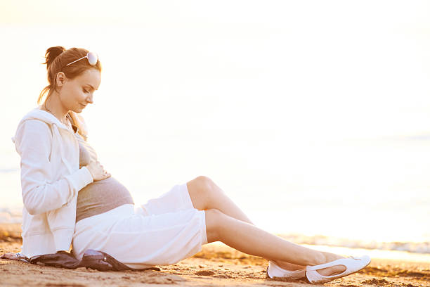 Pregnant woman on the beach stock photo