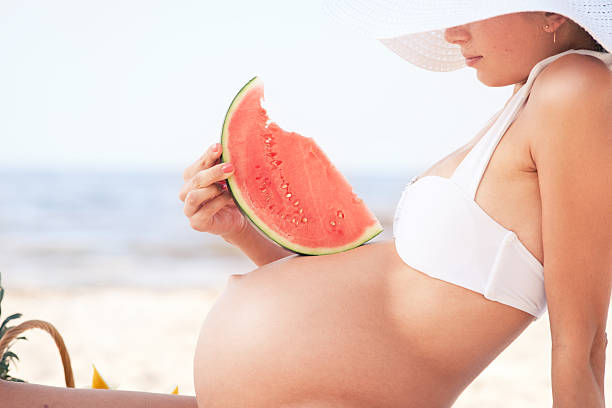Pregnant woman on the beach stock photo