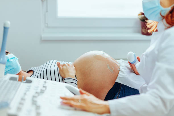 Pregnant woman on ultrasound pregnancy examination stock photo