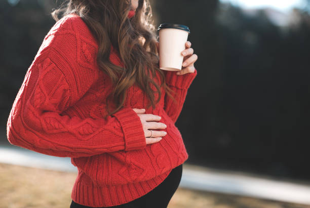 Pregnant woman outdoors stock photo