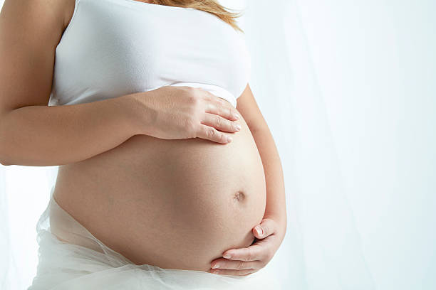 Pregnant woman Pregnant woman cradling unborn child human abdomen stock pictures, royalty-free photos & images