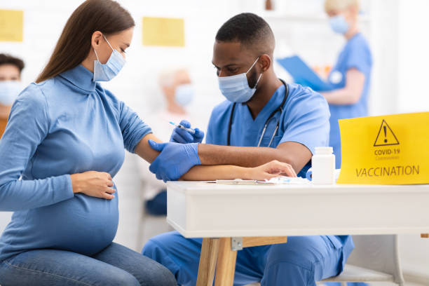 zwangere vrouw die coronavirus vaccin injectie shot in het ziekenhuis - pregnant stockfoto's en -beelden