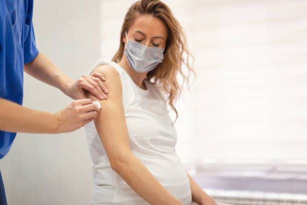 Pregnant woman taking a vaccination stock photo