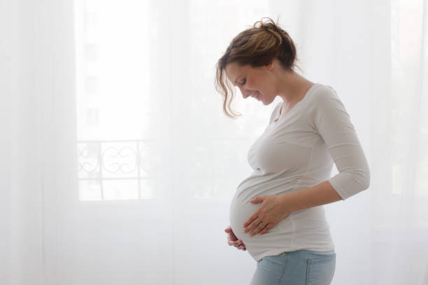 Pregnant woman touching belly stock photo