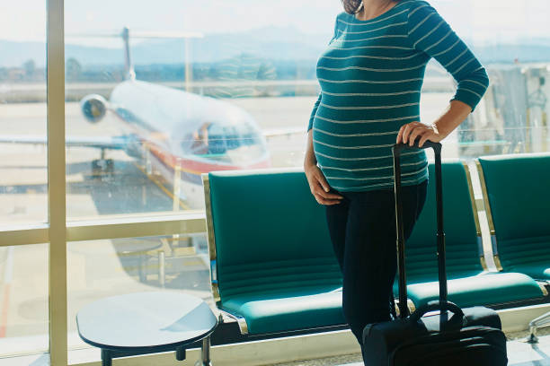 Pregnant woman traveling by plane stock photo