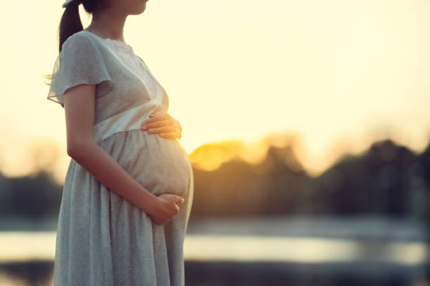 Pregnant woman walks in the park she feels relaxed stock photo