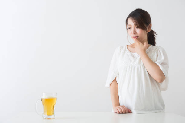 Pregnant woman watching beer Pregnant woman watching beer shy japanese woman stock pictures, royalty-free photos & images