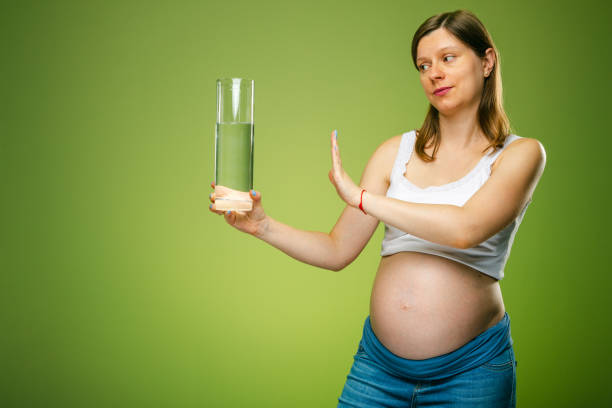 A pregnant woman with a glass of water, should a pregnant woman drink a lot of water or not. stock photo