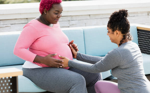 schwangere frau mit doula berühren baby beule - gefärbtes haar fotos stock-fotos und bilder
