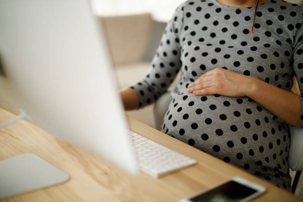 Pregnant woman working from home office stock photo
