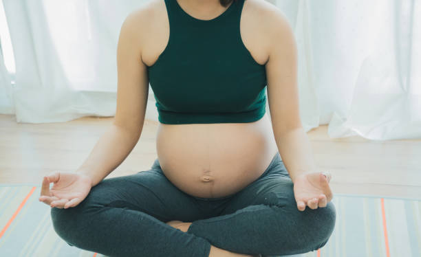Pregnant women playing yoga Healthy to strong baby in her belly. stock photo