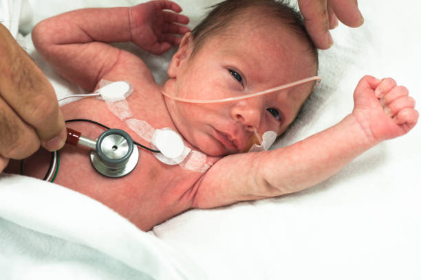 Premature baby in the neonatal intensive care stethoscopic examination stock photo