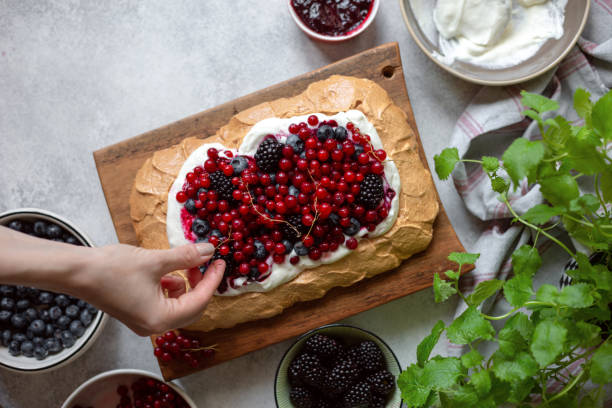 Preparing Berry Pavlova Cake with blueberry, blackberry and red currant. Preparing Berry Pavlova Cake with blueberry, blackberry and red currant. pavlova dessert photos stock pictures, royalty-free photos & images