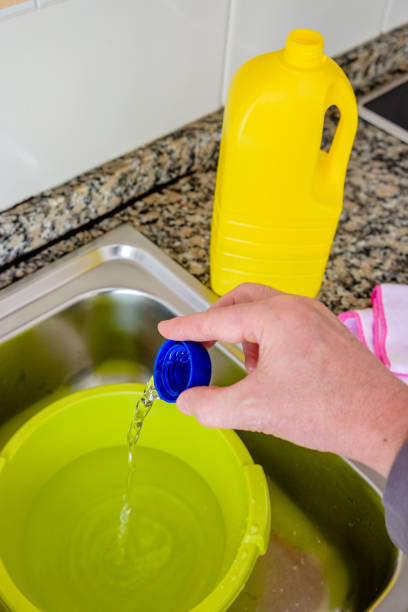 Preparing disinfectant to clean during the Coronavirus pandemic. Bleach and water is one of the most effective and accessible disinfectants for the population to combat Covid-19. bleach stock pictures, royalty-free photos & images
