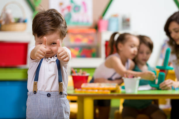 Preschooler Happy little boy posing in classroom. child care stock pictures, royalty-free photos & images