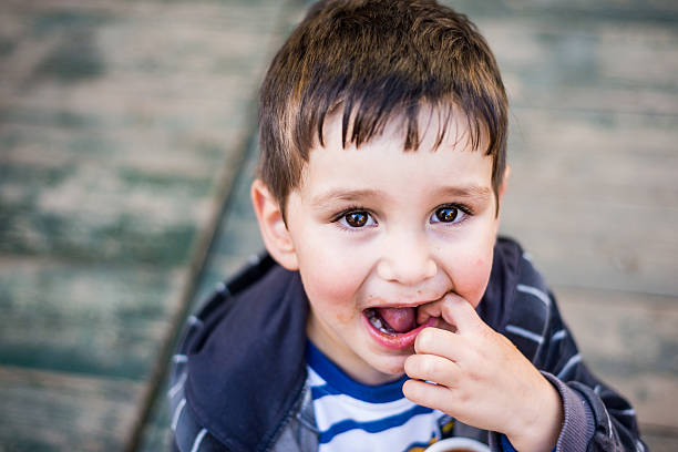 Preschooler with finger in his mouth stock photo