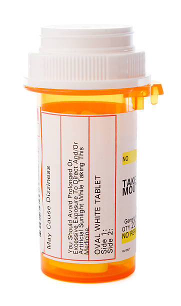 Prescription Medicine in Pill Bottle, Healthcare Drugs Isolated on White A bottle of prescription medicine isolated against a white background. The labeled container of whit tablet pills holds medications for a patient's healthcare needs during illness or for a chronic, managed health condition. Warnings and instructions are in text on the generic label. No specific or proprietary information is shown. prescription medicine stock pictures, royalty-free photos & images