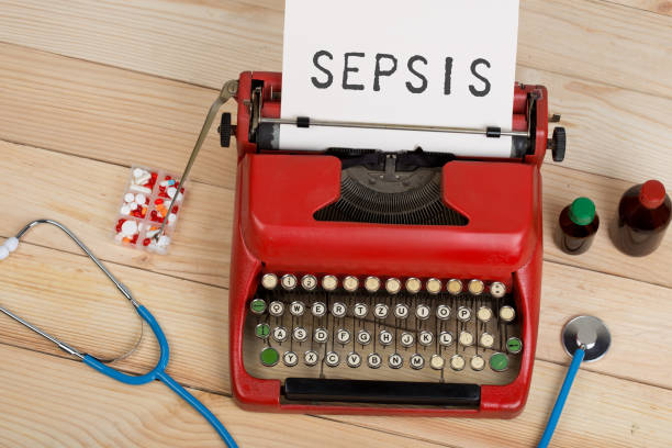 Prescription medicine or medical diagnosis - doctor workplace with blue stethoscope, pills, red typewriter with text Sepsis stock photo