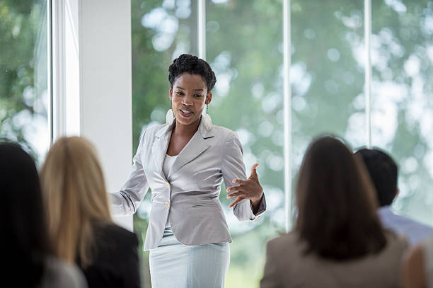 Presenting to New Employees A multi-ethnic group of business professionals are getting training at the corporate office. A woman is presenting on their business concepts. presentation speech stock pictures, royalty-free photos & images
