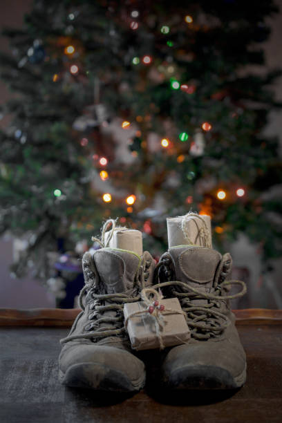 präsentiert in wanderschuhen unter weihnachtsbaum - nikolaus stiefel stock-fotos und bilder