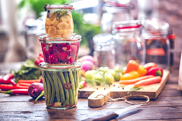 Preserving Organic Vegetables in Jars Preserving organic vegetables in jars like grean beans, garlic, carrots, cucumbers, tomatoes, chilis, paprika and radishes. pickle stock pictures, royalty-free photos & images