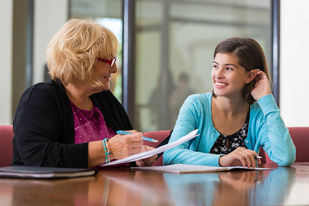 Preteen girl meeting with school counselor or therapist Preteen girl meeting with school counselor or therapist guide occupation stock pictures, royalty-free photos & images