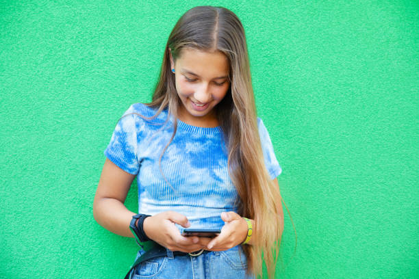 Pre-teen girl using phone Pre-teen girl using phone on green background
using a social media app on her smartphone and texting smart phone green background stock pictures, royalty-free photos & images