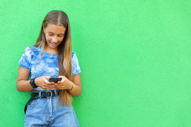 Pre-teen girl using phone Pre-teen girl using phone on green background
using a social media app on her smartphone and texting smart phone green background stock pictures, royalty-free photos & images