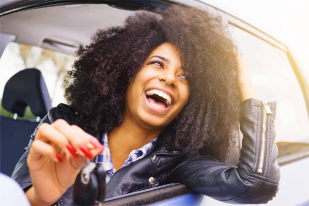 pretty afro-hair girl smiling from her car stock photo